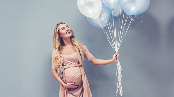 Schwangere Frau mit Luftballons in der Hand
